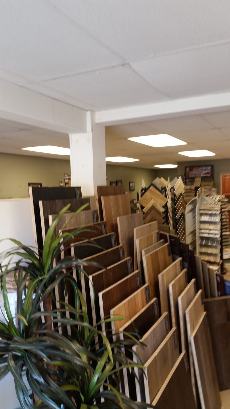 Racks of flooring samples standing on the showroom floor beside a display wall.